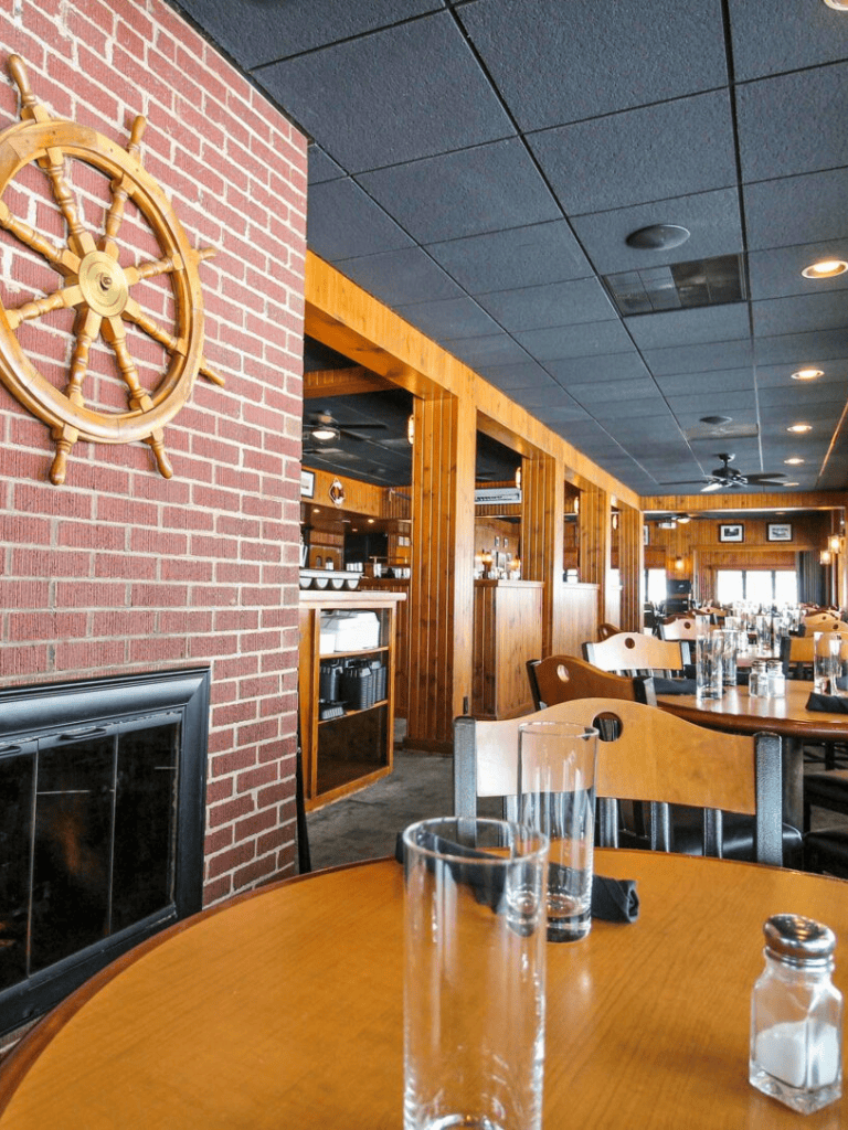 Steakhouse interior with wooden accents, brick walls, and nautical decor, perfect for dining and gatherings.