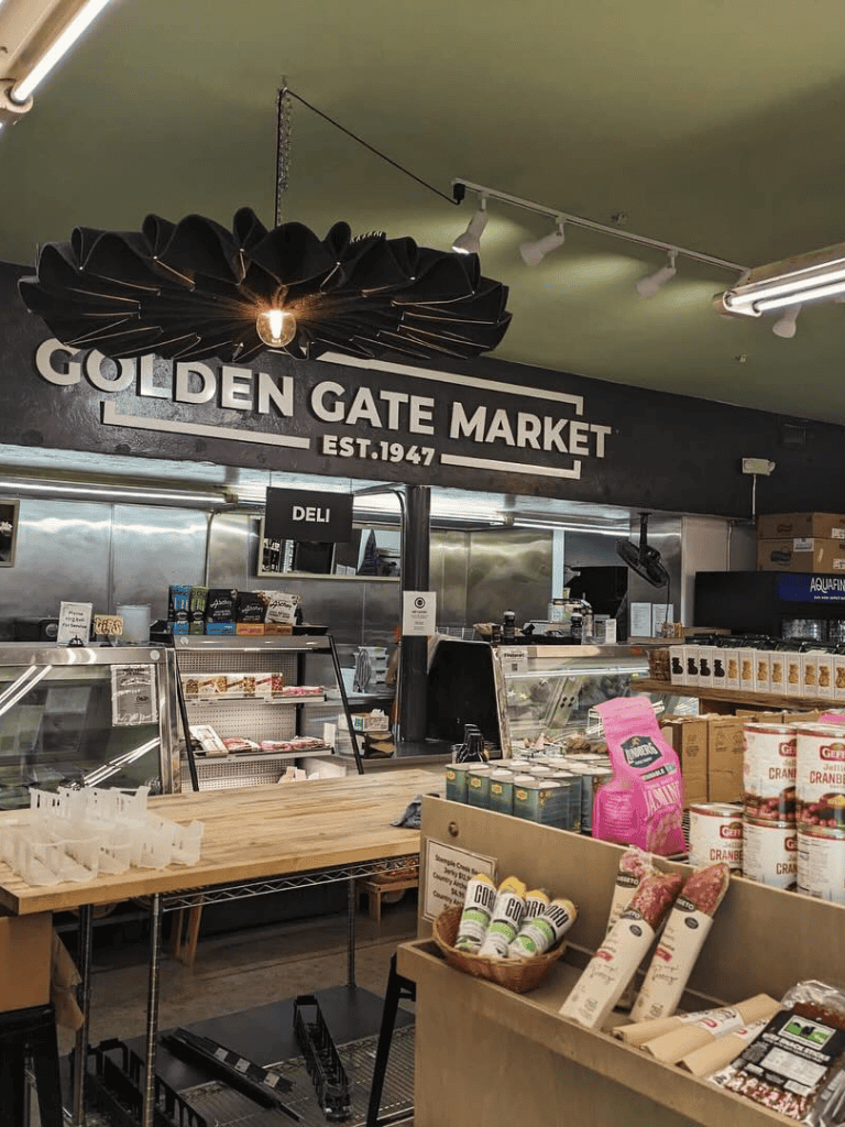 Vintage grocery store interior at Golden Gate Market, established 1947, with fresh and packaged foods.