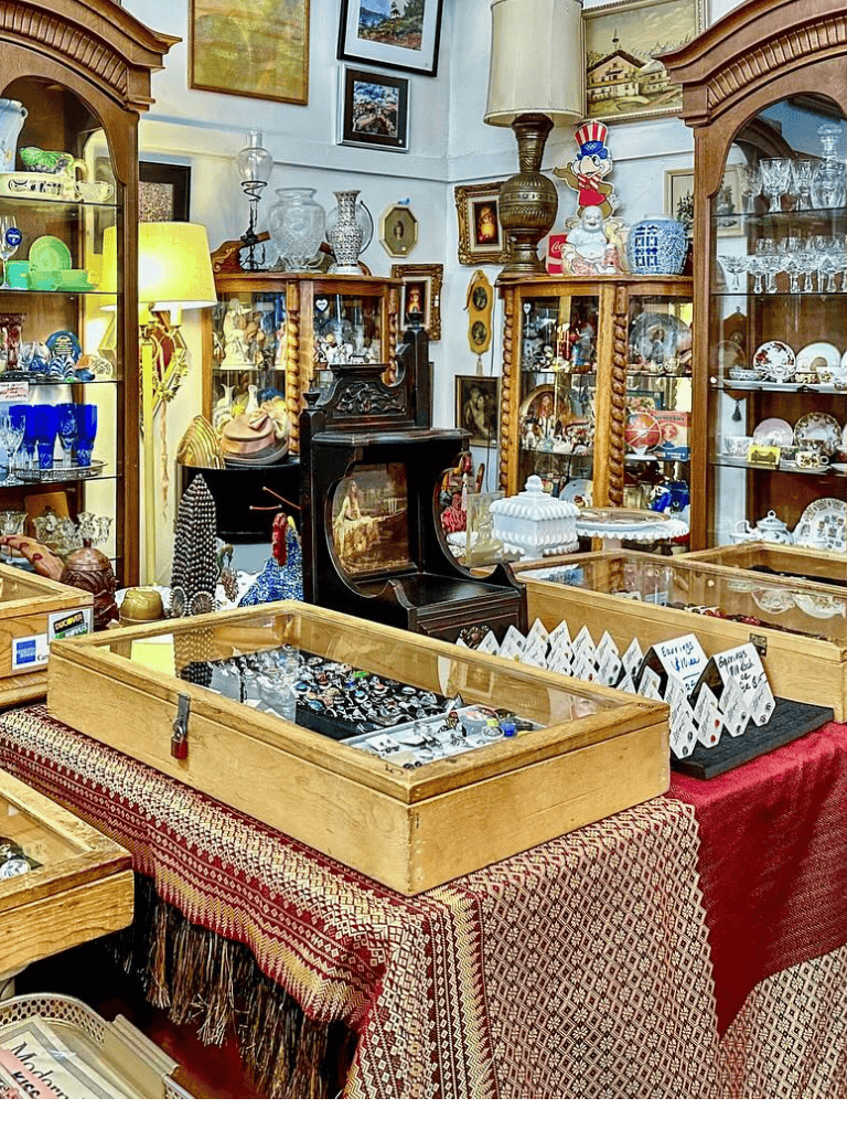 Vintage antique collectibles at QuestForDirections thrift store, glassware, ceramics, jewelry, and decor displays.