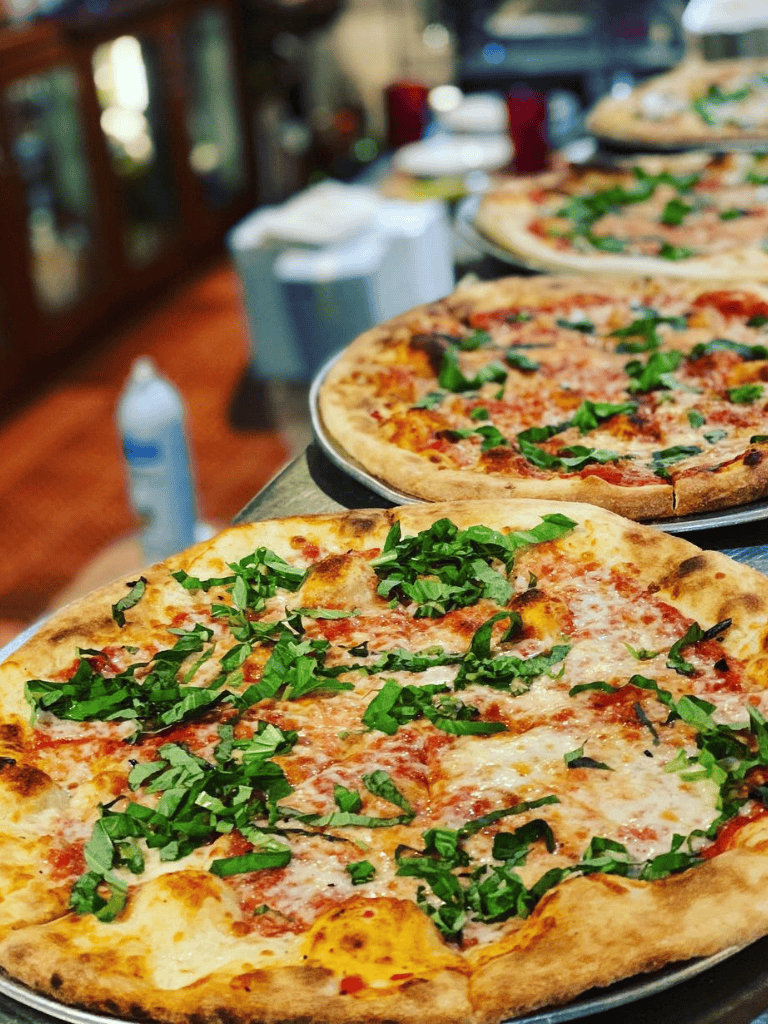 Freshly baked cheese and basil pepperoni pizza at a cozy pizzeria.