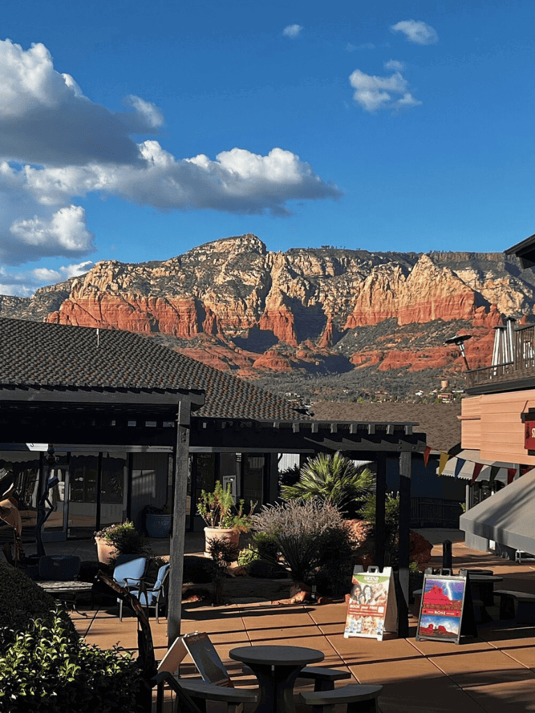 Stunning view of Sedona red rocks from an outdoor patio with seating and potted plants.