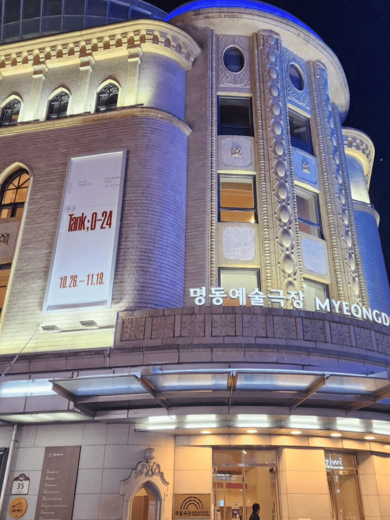 Historic building illuminated at night, featuring Korean art theater signage.
