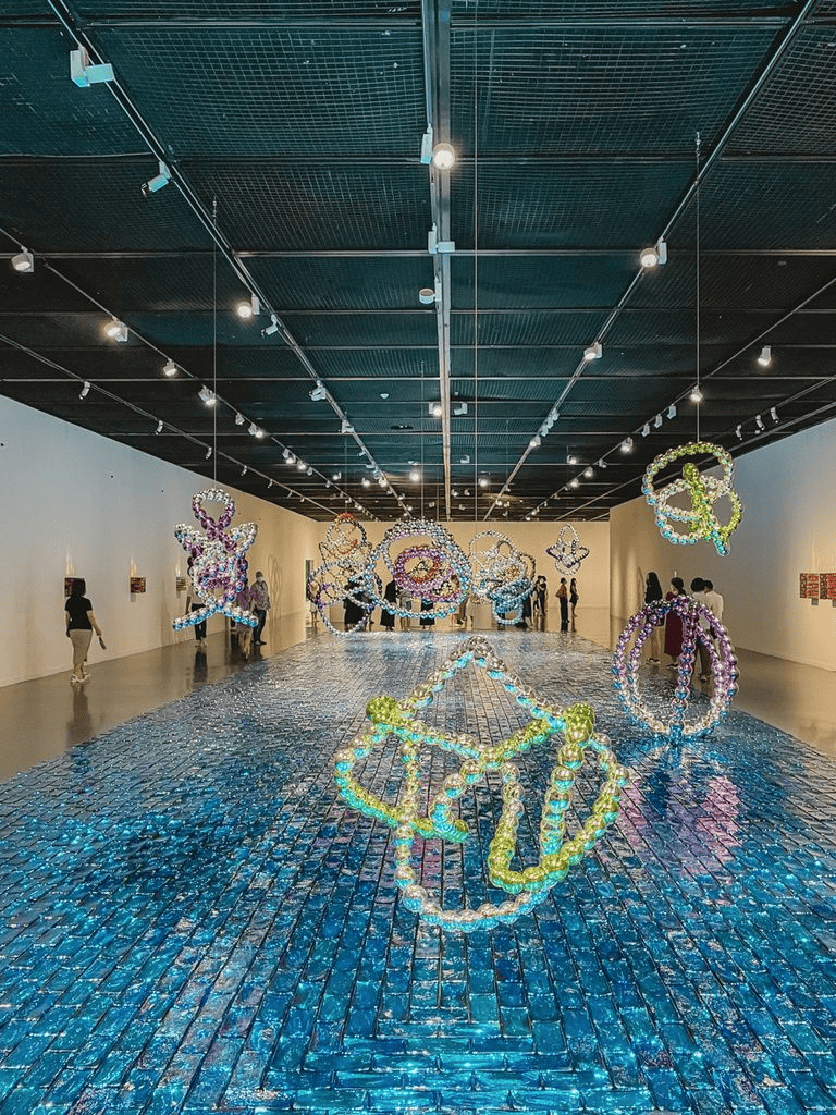 Colorful beaded jewelry artwork display at QuestForDirections art exhibit.