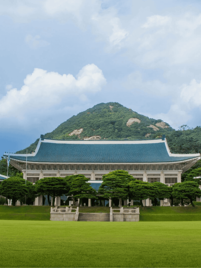 Serene mountain temple with traditional architecture amidst lush greenery and scenic mountain backdrop.
