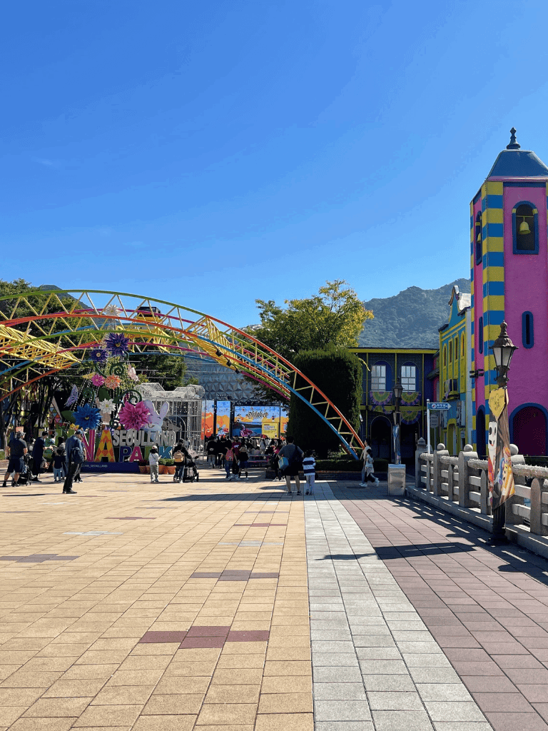 Colorful amusement park entrance with vibrant buildings and joyful visitors, perfect for family fun and entertainment.