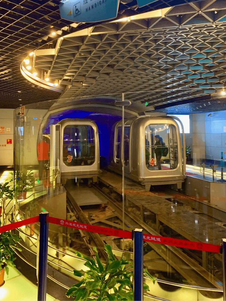 Modern airport monorail train at transit station, indoor rapid transit system, QuestForDirections.