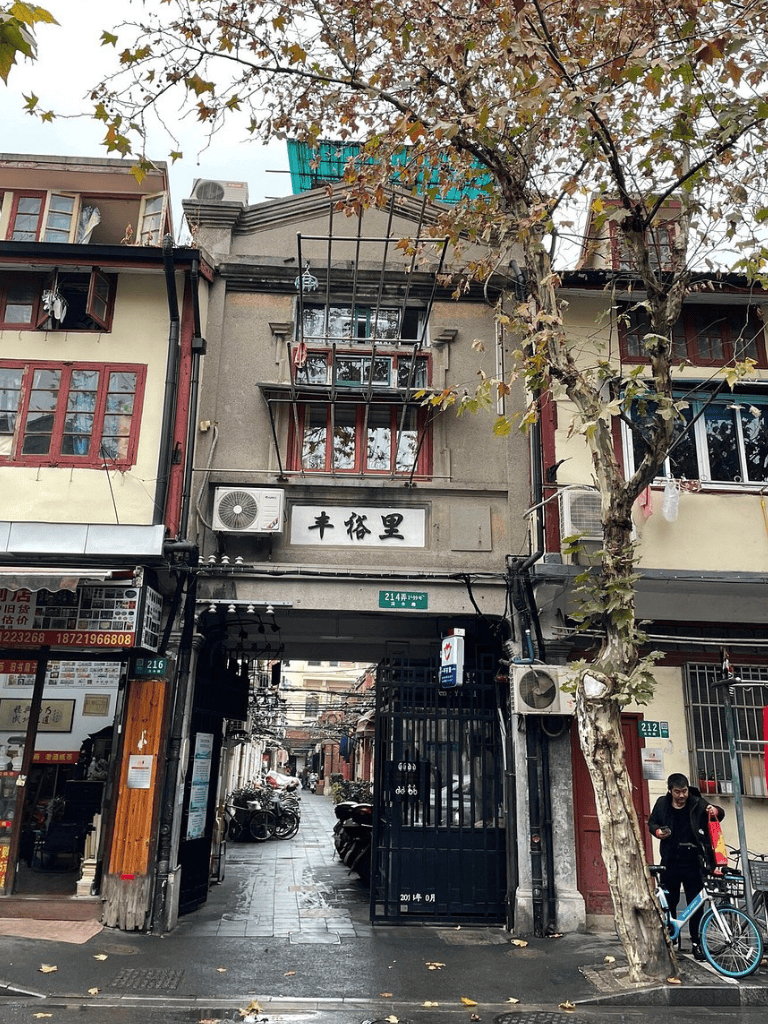 Old city alleyway with traditional buildings, narrow passage, and bicycles, located in a historic Asian neighborhood.