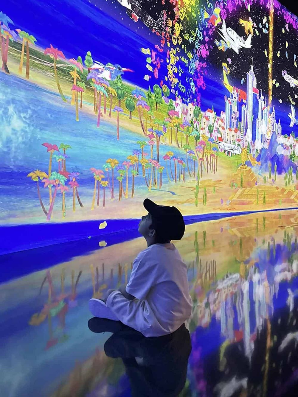 Vibrant digital art mural with cityscape, colorful trees, and night sky reflecting on water, perfect for immersive exploration.