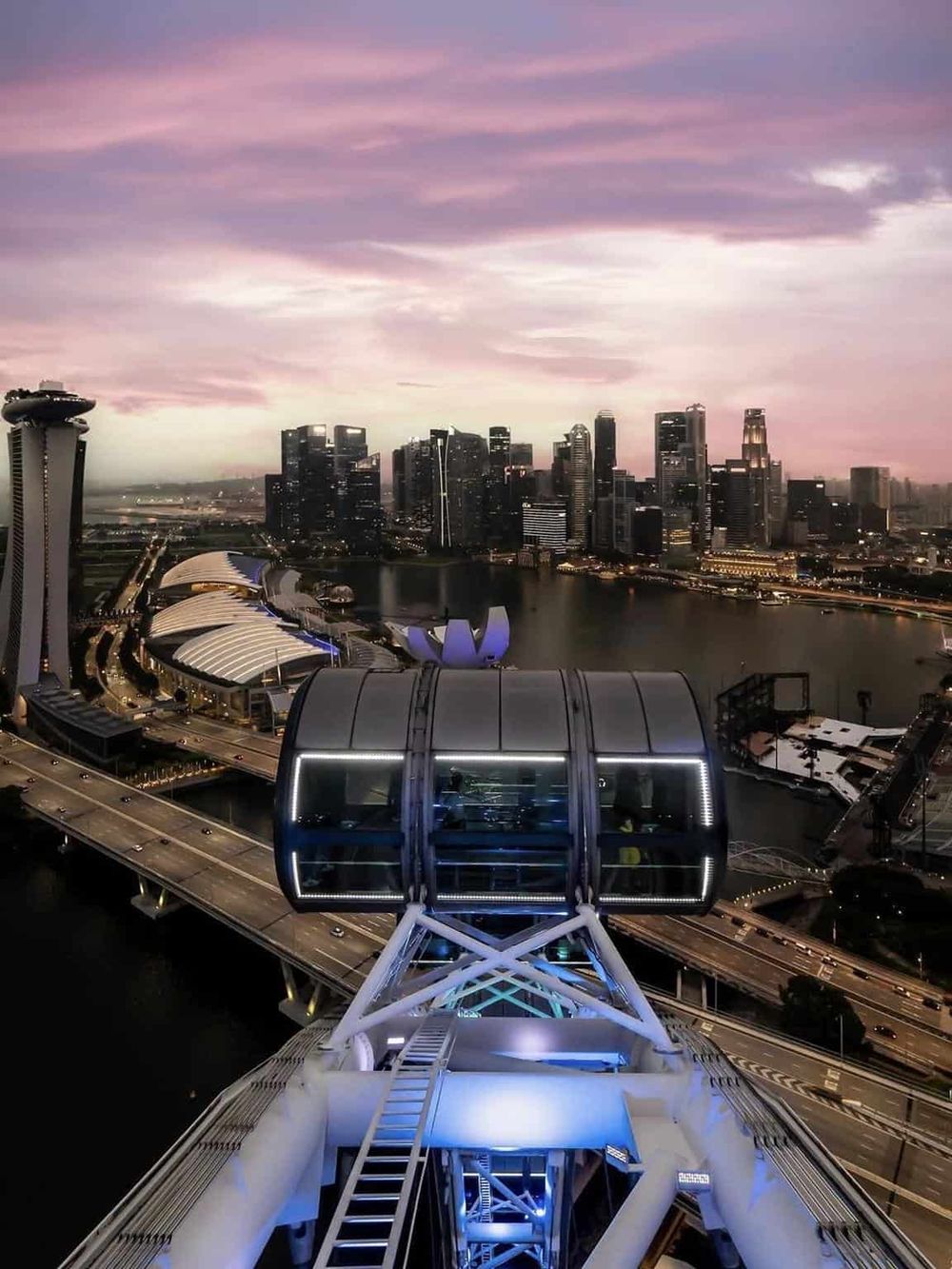Breathtaking view of Singapore skyline with the iconic observation wheel at sunset.