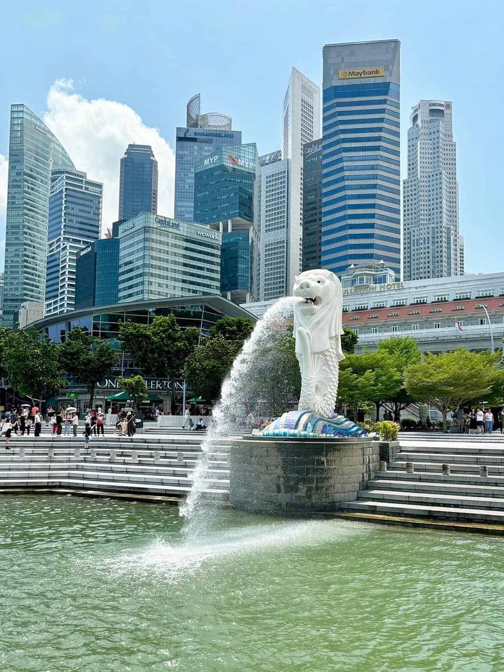 Modern Singapore skyline with iconic Merlion statue and business district.