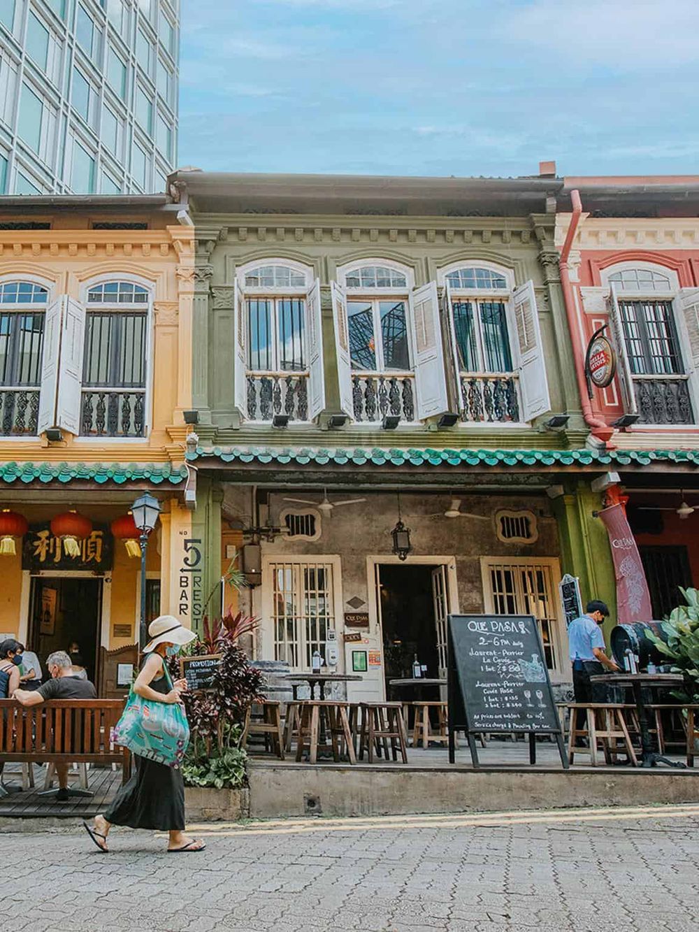 Colorful heritage building with outdoor cafe and street scene, popular tourist destination.