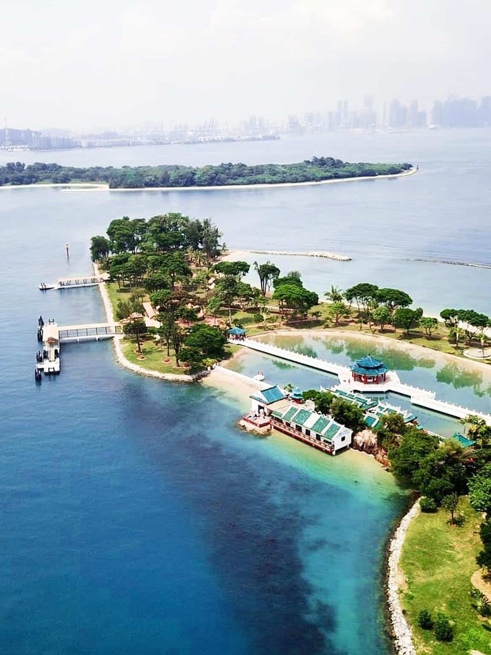 Scenic aerial view of QuestForDirections island with lush greenery and turquoise waters, promoting navigation and travel solutions.