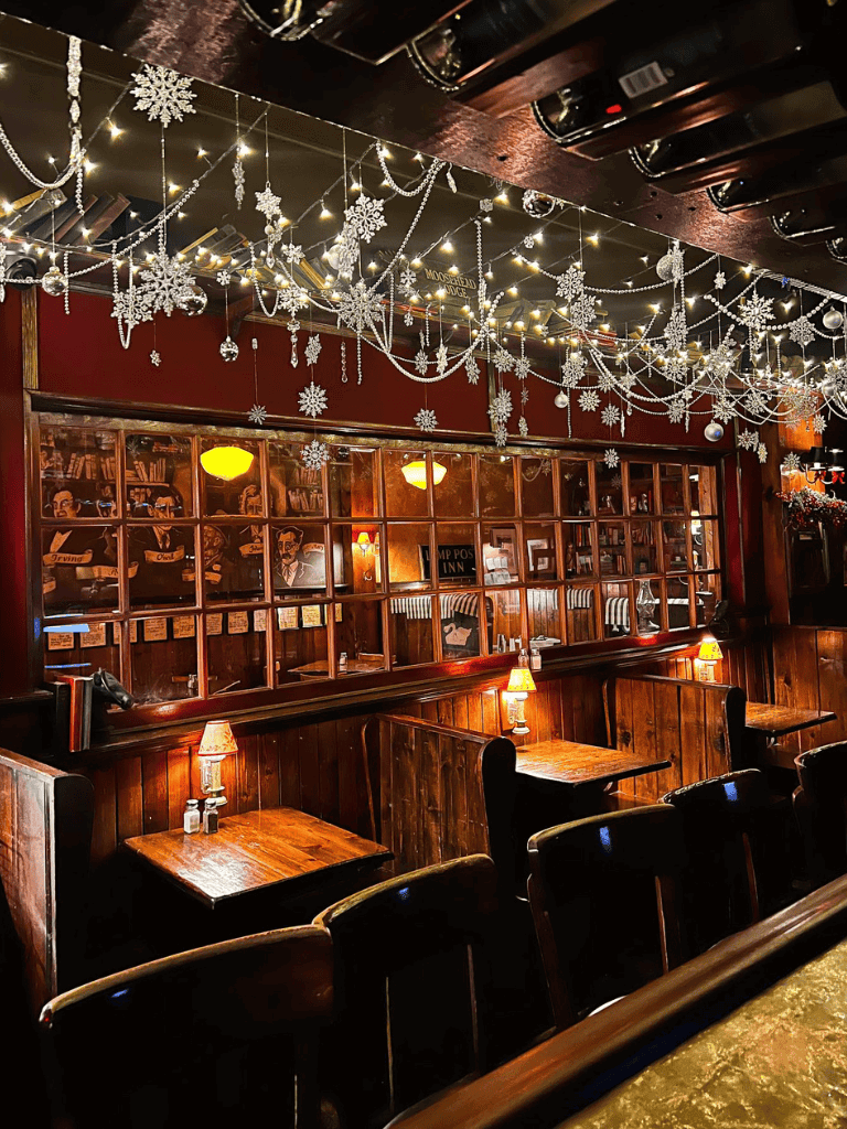 Festive Christmas decor with string lights and snowflake ornaments in a cozy bar setting.