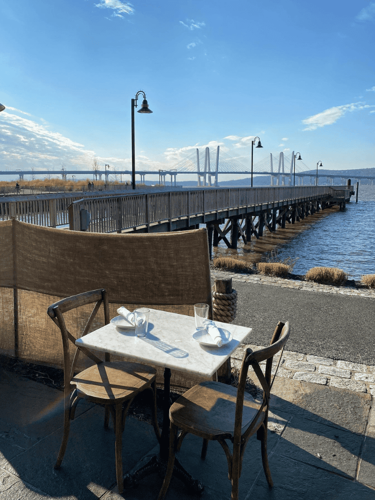 Relaxing waterfront dining at QuestForDirections, scenic views of the river and bridge, perfect for leisure and good cuisine.