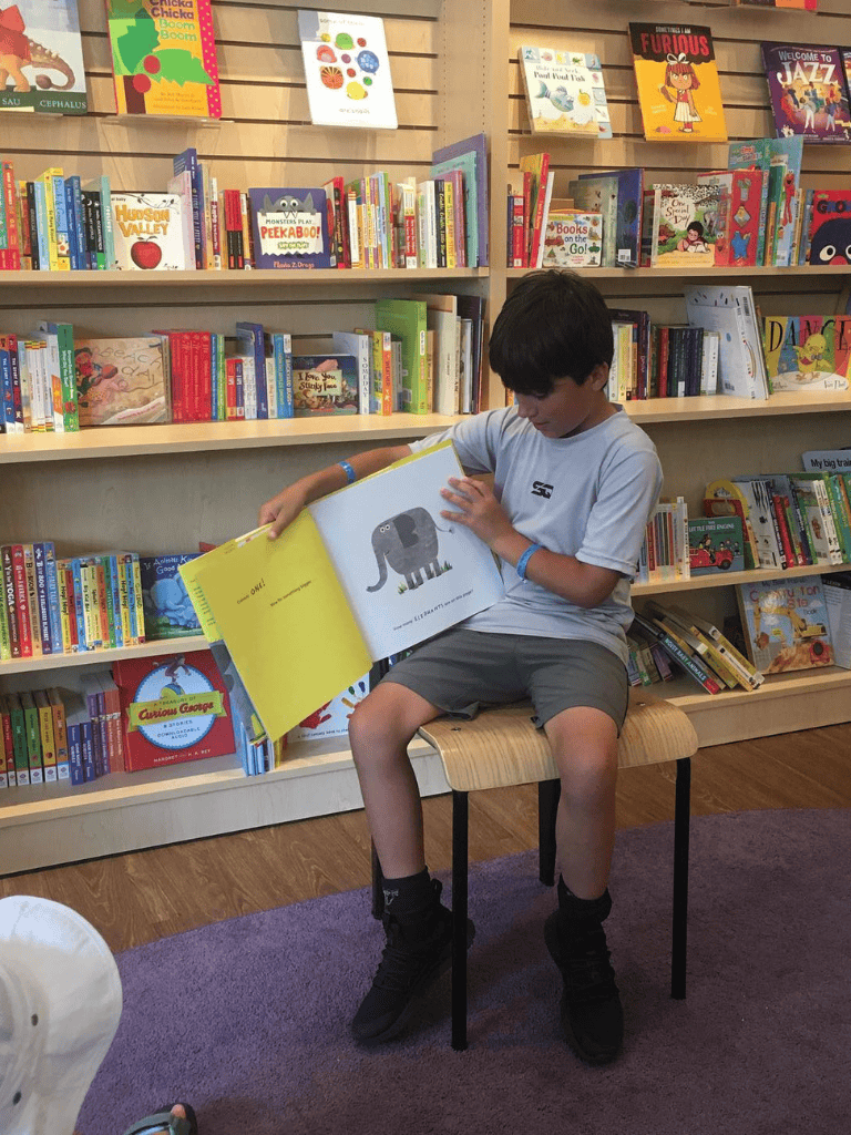 Kids reading colorful children's books at a bookstore.