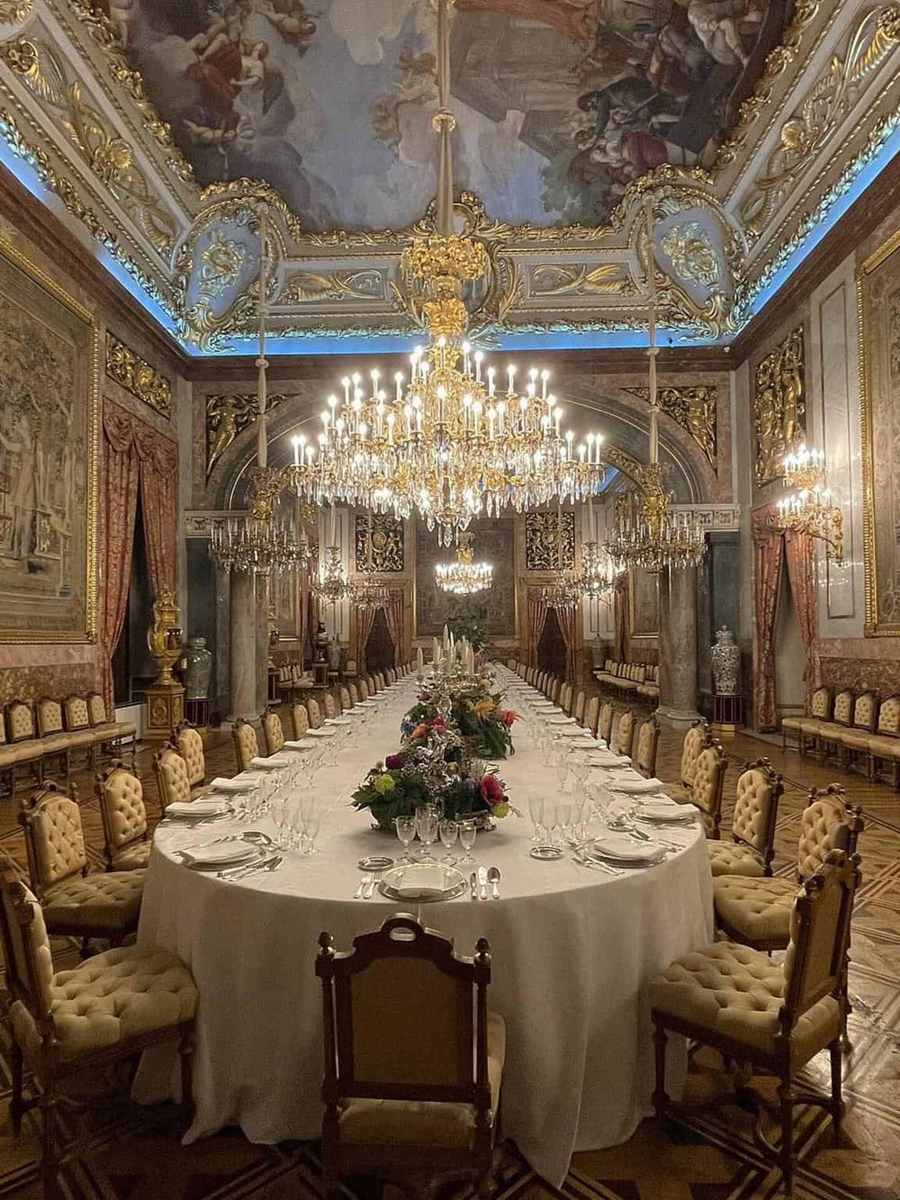 Luxurious royal dining room with ornate gold accents and grand chandeliers, perfect for elegant events.