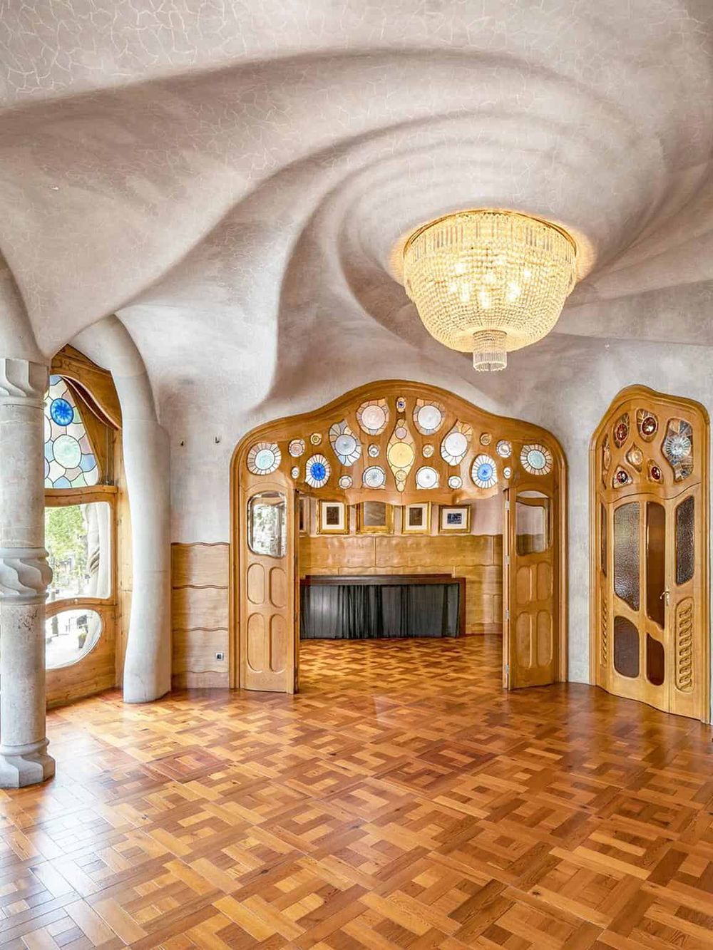 Colorful modern interior of a house with unique wooden and stained glass design elements.