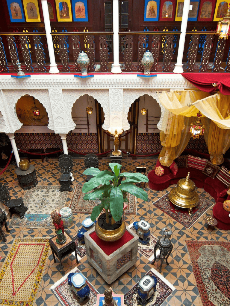 Exotic Moroccan-style lounge with ornate decor, vibrant textiles, and lush greenery for unique travel experiences.