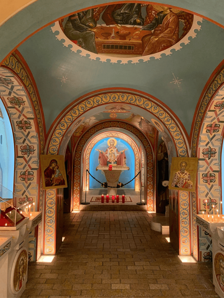 Ancient church interior with religious icons and colorful murals, emphasizing spiritual tranquility and artistic craftsmanship.