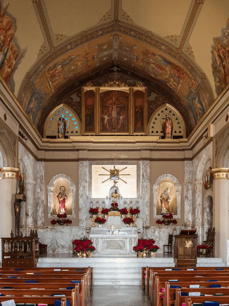 Altar inside a church with religious statues and Christmas decorations.