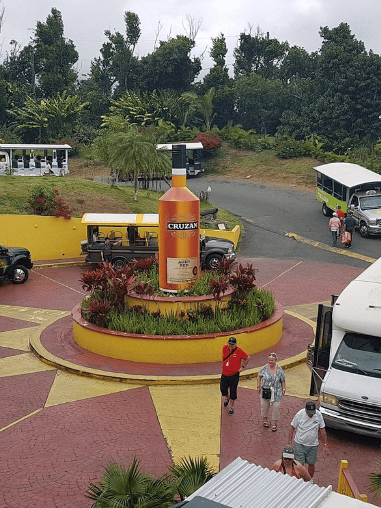 Cruzan Rum advertisement sculpture at QuestForDirections location with tourists and vehicles in the background.