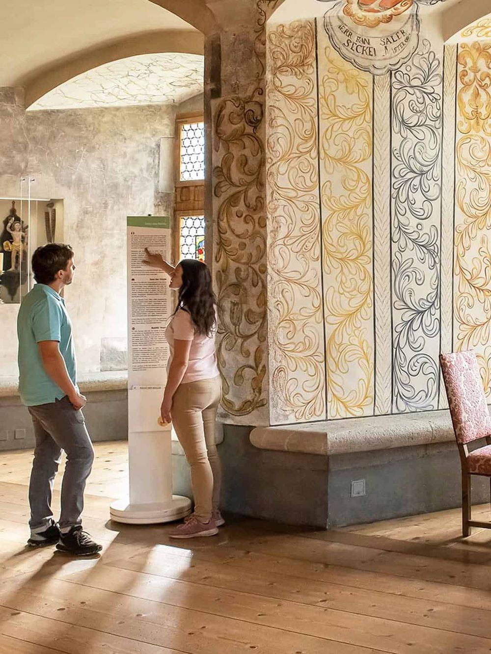 Intriguing museum scene showing two visitors engaging with educational displays, showcasing the quest for knowledge in a historical setting.