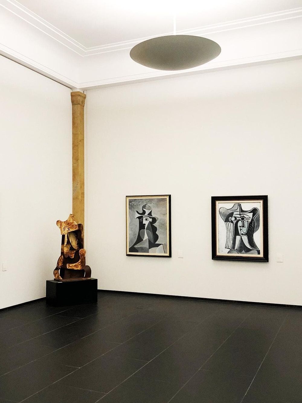 Modern art gallery interior showcasing abstract paintings and sculptures, ideal for art enthusiasts and cultural visitors.