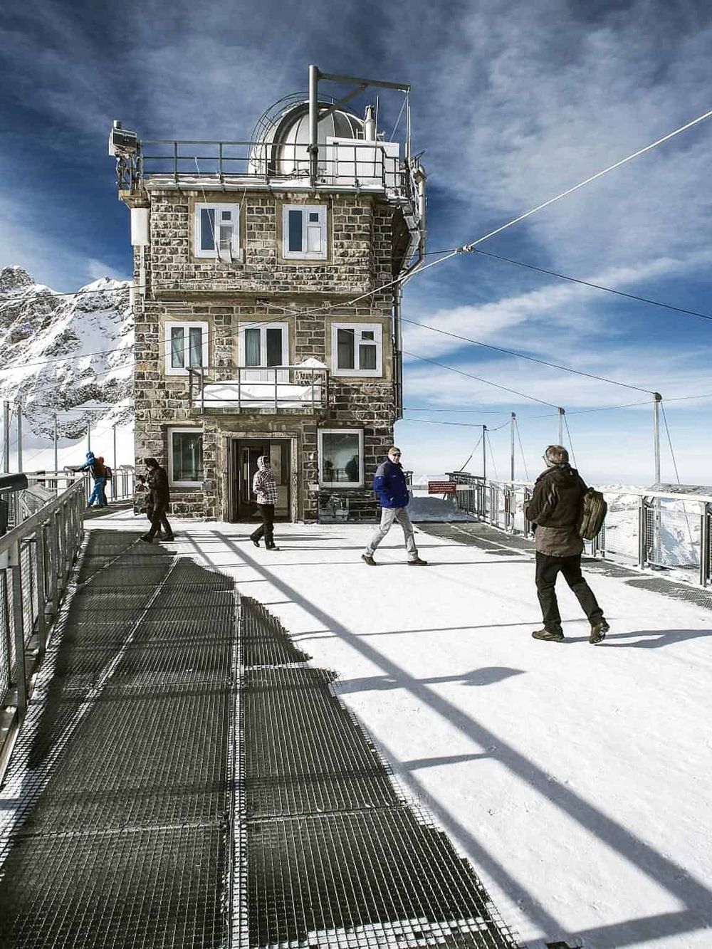 Snowy mountain observatory building with tourists at summit, winter mountain adventure, scenic alpine landmark, QuestForDirections.