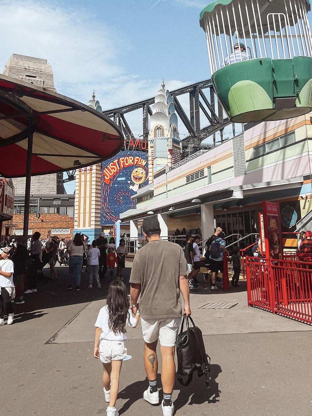 Bright amusement park scene with rides and visitors enjoying a fun day out.