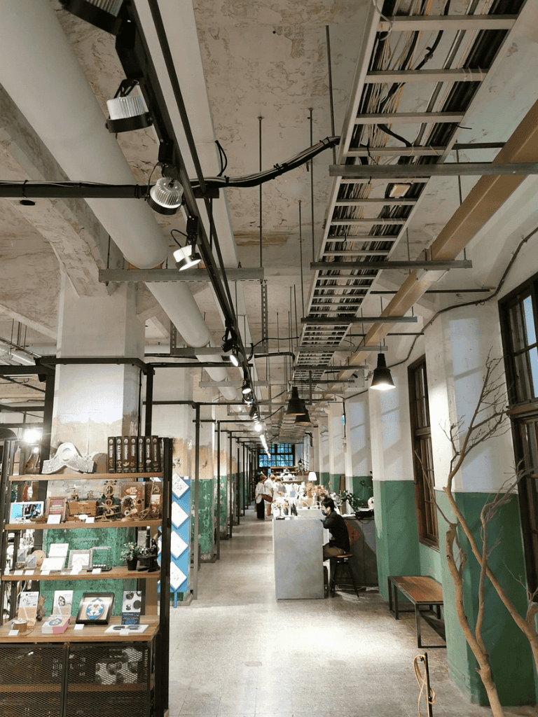 Industrial styled cafe interior with exposed pipes and beams, ambient lighting, and cozy seating areas.