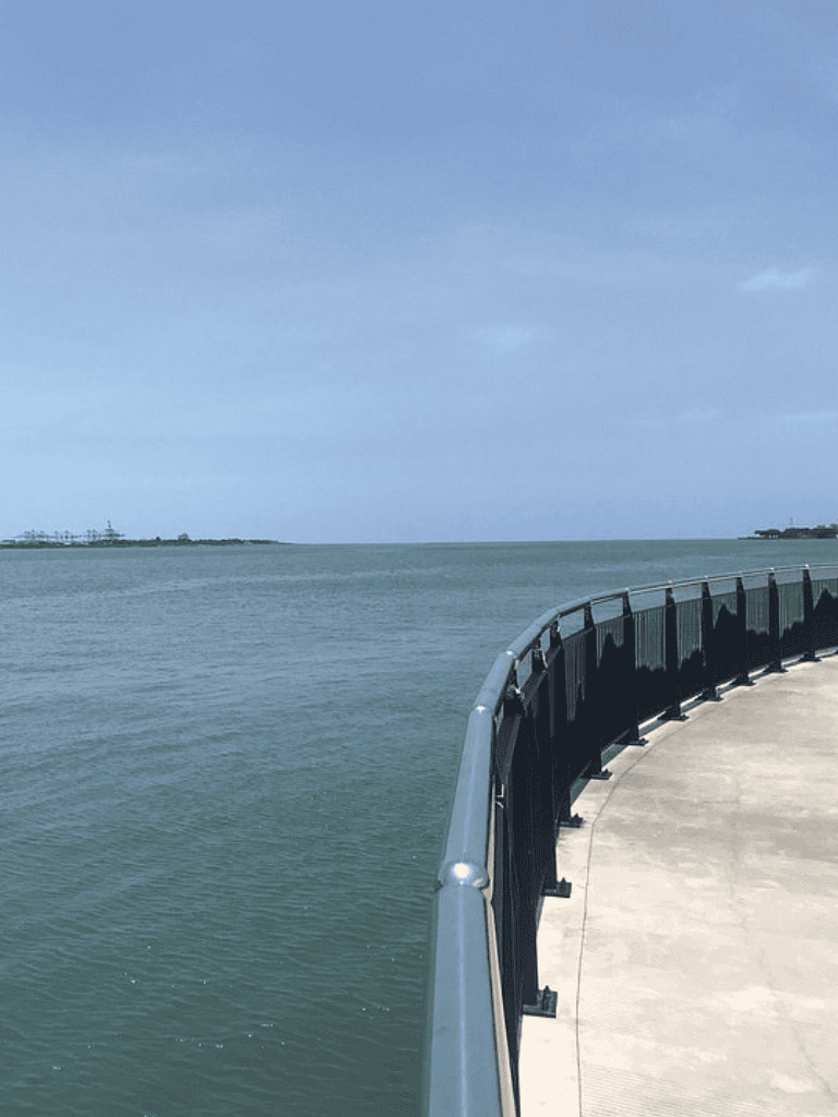 Seaside walkway with ocean view and clear skies, ideal for scenic oceanfront walks.
