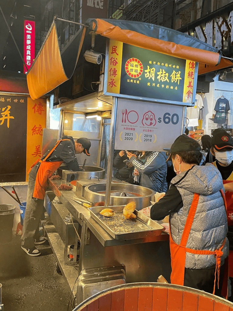 Fresh street food vendor preparing traditional snacks on bustling night street market.