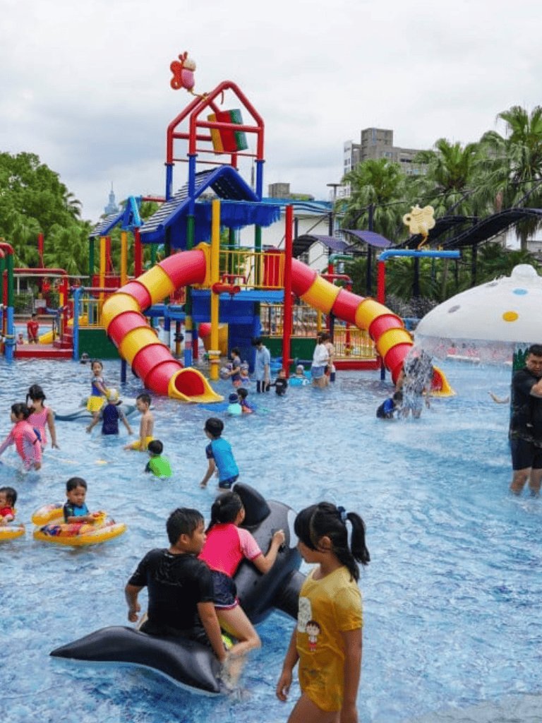 Colorful water park with slides and kids playing in pool, family fun at QuestForDirections.