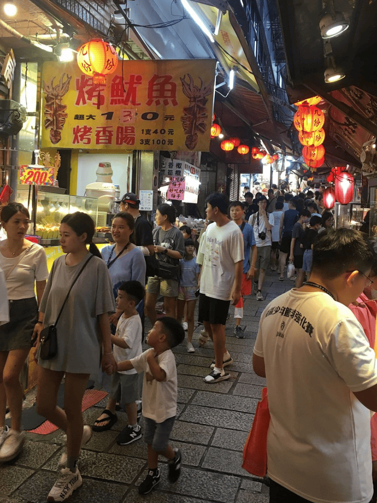 Colorful Night Market Street in Asia with Lanterns and Crowds.
