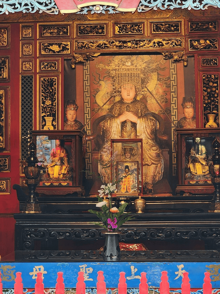 Intricate altar with traditional Buddhist statues and ornate woodwork decoration.