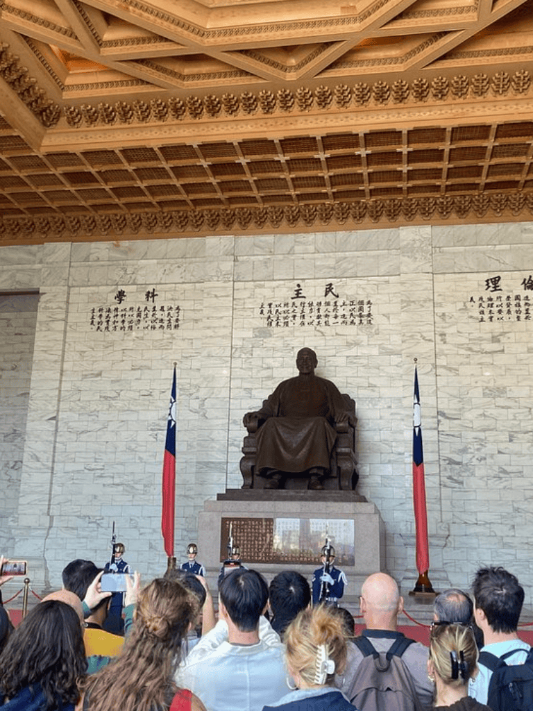 Statue of Sun Yat-sen in Taipei, Taiwan, with visitors taking photos in front.