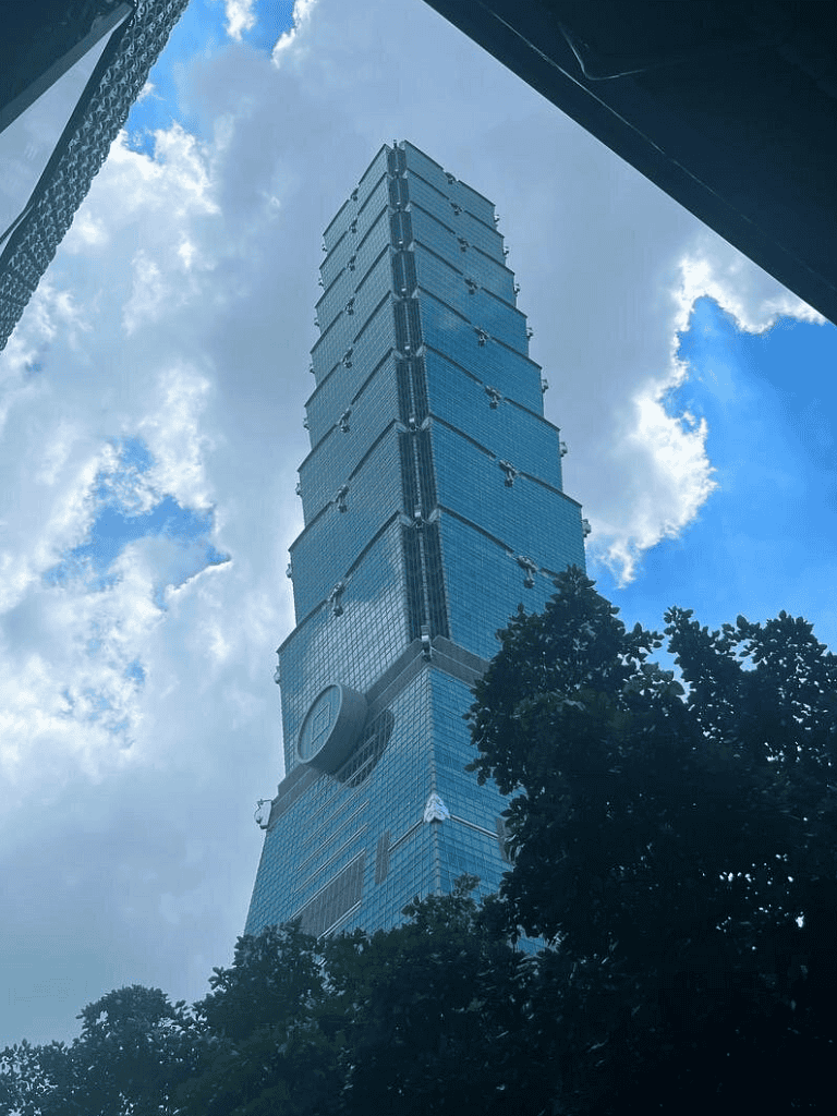 Skyline view of Taipei 101 skyscraper with blue sky and clouds, iconic Taipei Tower, Taipei cityscape, travel destination.