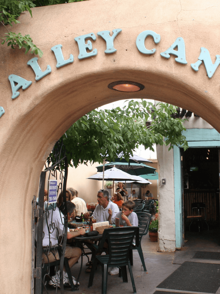 Outdoor restaurant patio with diners, shaded by umbrellas, inviting atmosphere for family dining.