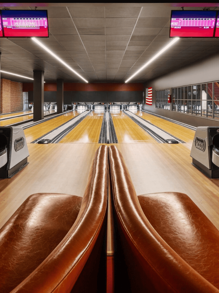 Bowling alley interior with leather seating and lanes at QuestForDirections. Perfect for fun, leisure, and entertainment.
