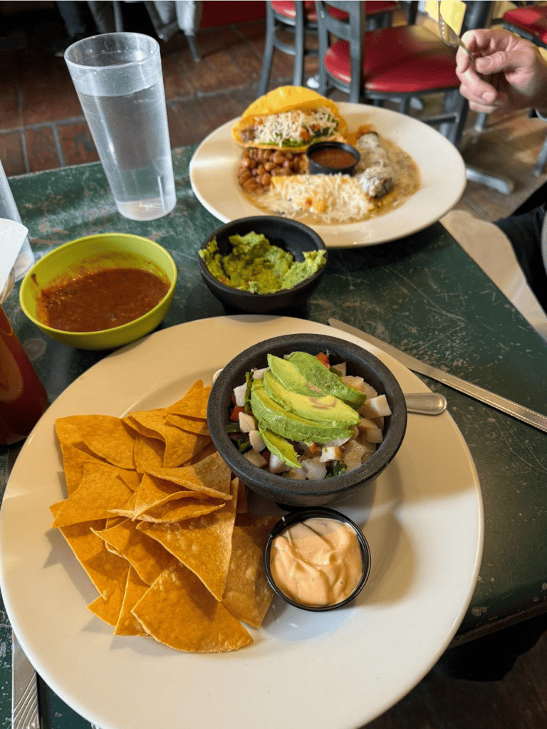 Fresh Mexican dishes with guacamole, salsa, tacos, and nachos in a vibrant restaurant setting.
