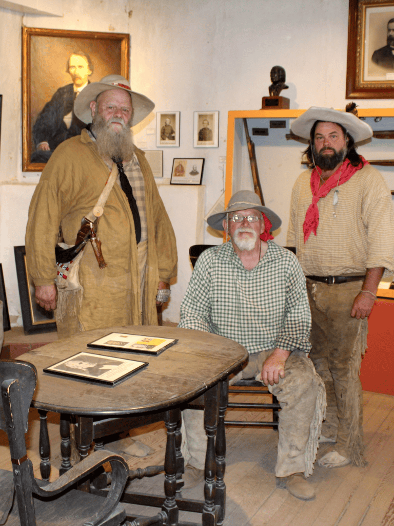 Old West pioneers in historical attire at QuestForDirections museum, showcasing early American history.