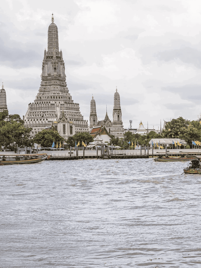 Ancient Thai temple and river view in Bangkok, Thailand, showcasing cultural landmarks and scenic waterways.