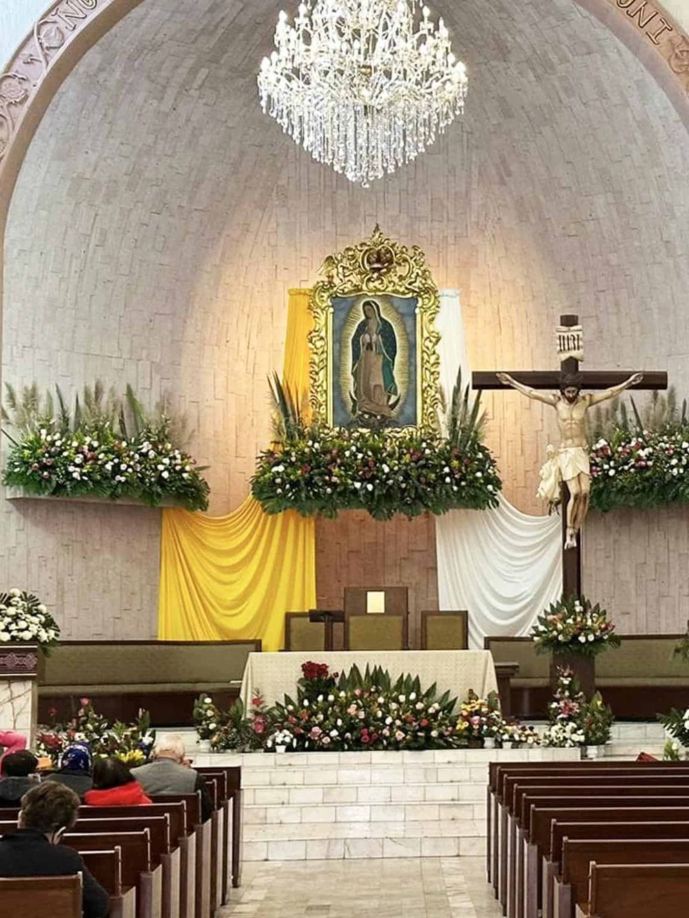 Elegant church altar decorated with vibrant flowers and religious icons for a wedding or religious ceremony.