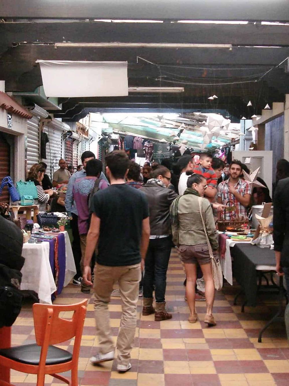 Vibrant indoor market at QuestForDirections, bustling with shoppers exploring local crafts and food stalls.