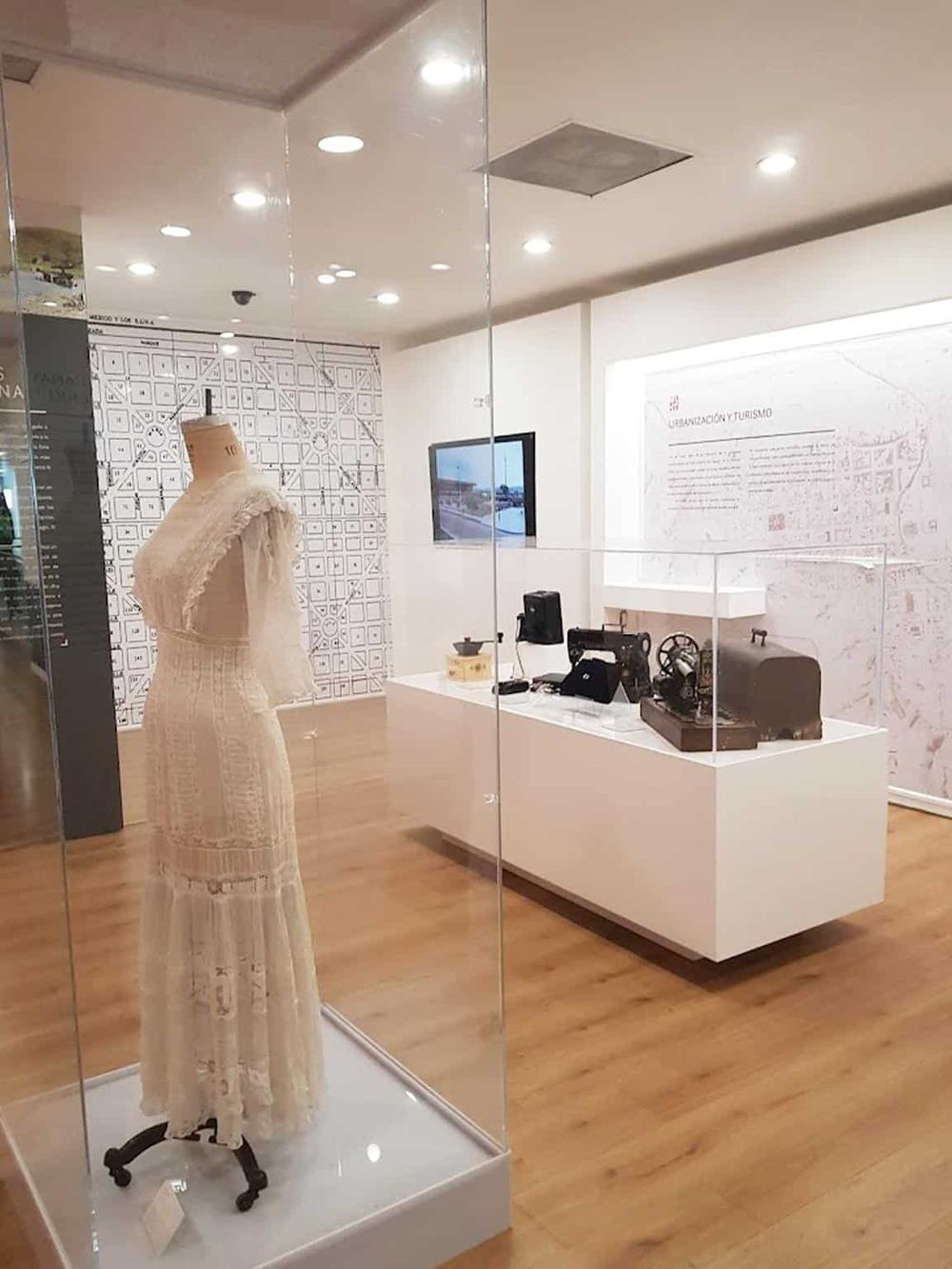 Vintage sewing machine and dress display at the Quest for Directions tourism and urbanization museum.