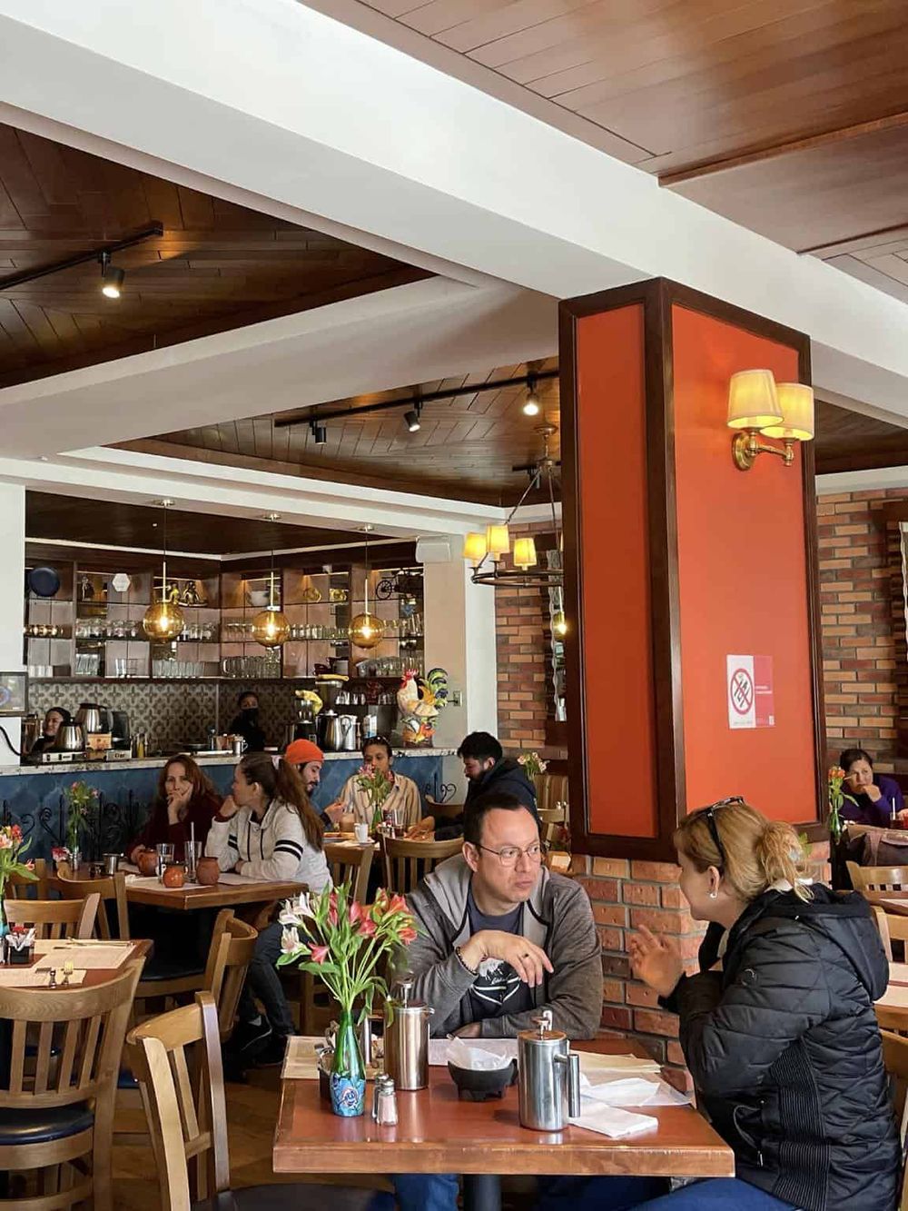 Cozy restaurant interior with customers dining, warm lighting, and vibrant decor, ideal for enjoying diverse cuisines and social gatherings.