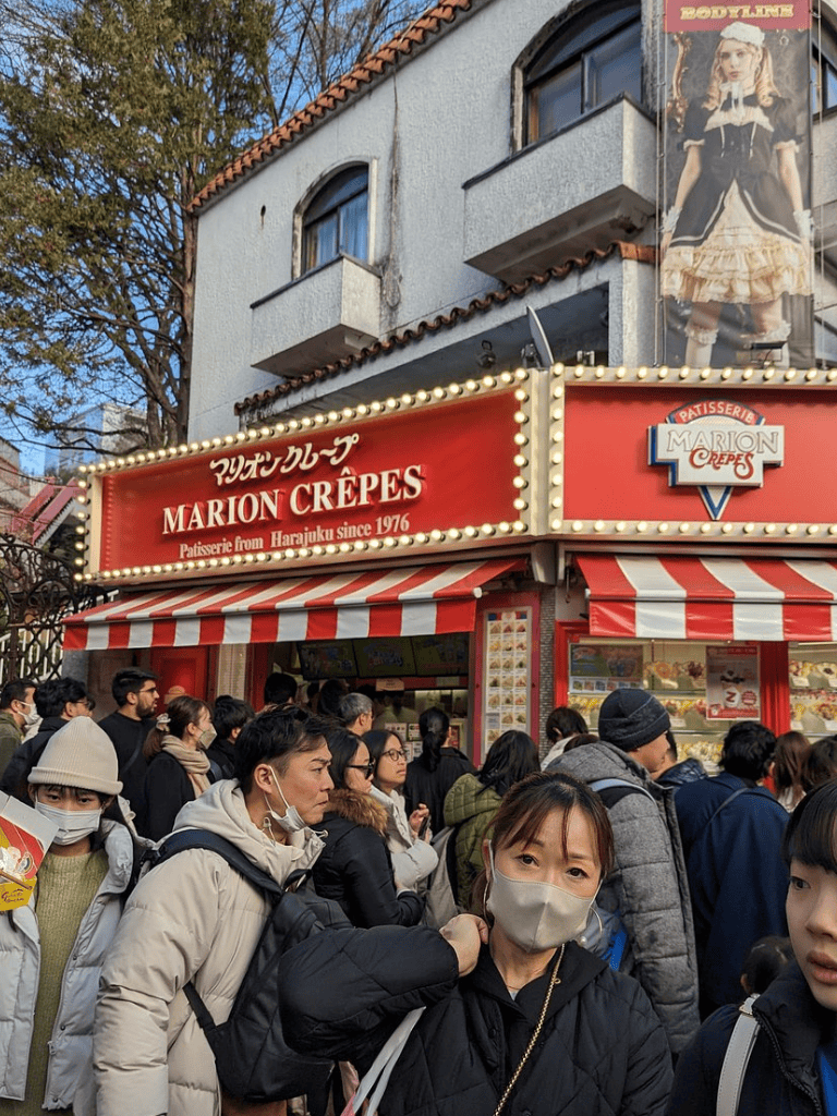 Busy crowd outside Marion Crêpes bakery in Harajuku, Tokyo, popular for Japanese and French pastries.