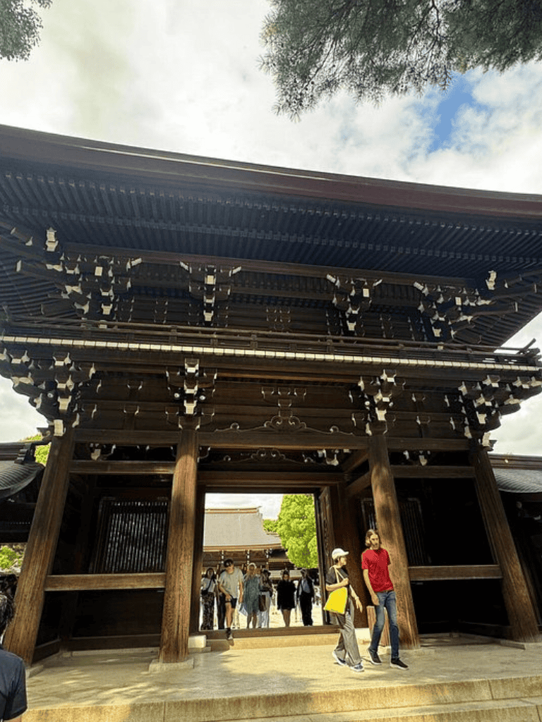 Intricate traditional Japanese temple gate with visitors exploring the historic site.