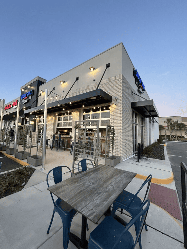 Outdoor dining area of QuestForDirections restaurant, modern facade and stylish seating.