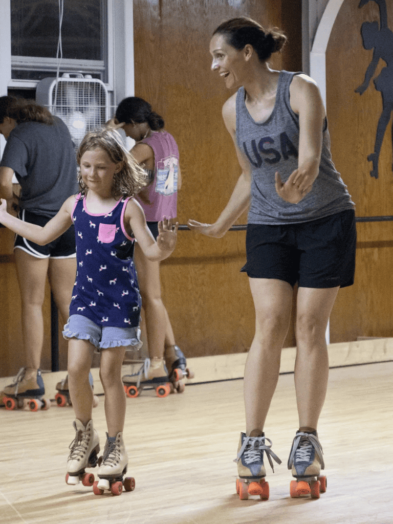 Skating lesson for kids, recreational roller skating class, beginner roller skating for children, indoor skating rink activity.